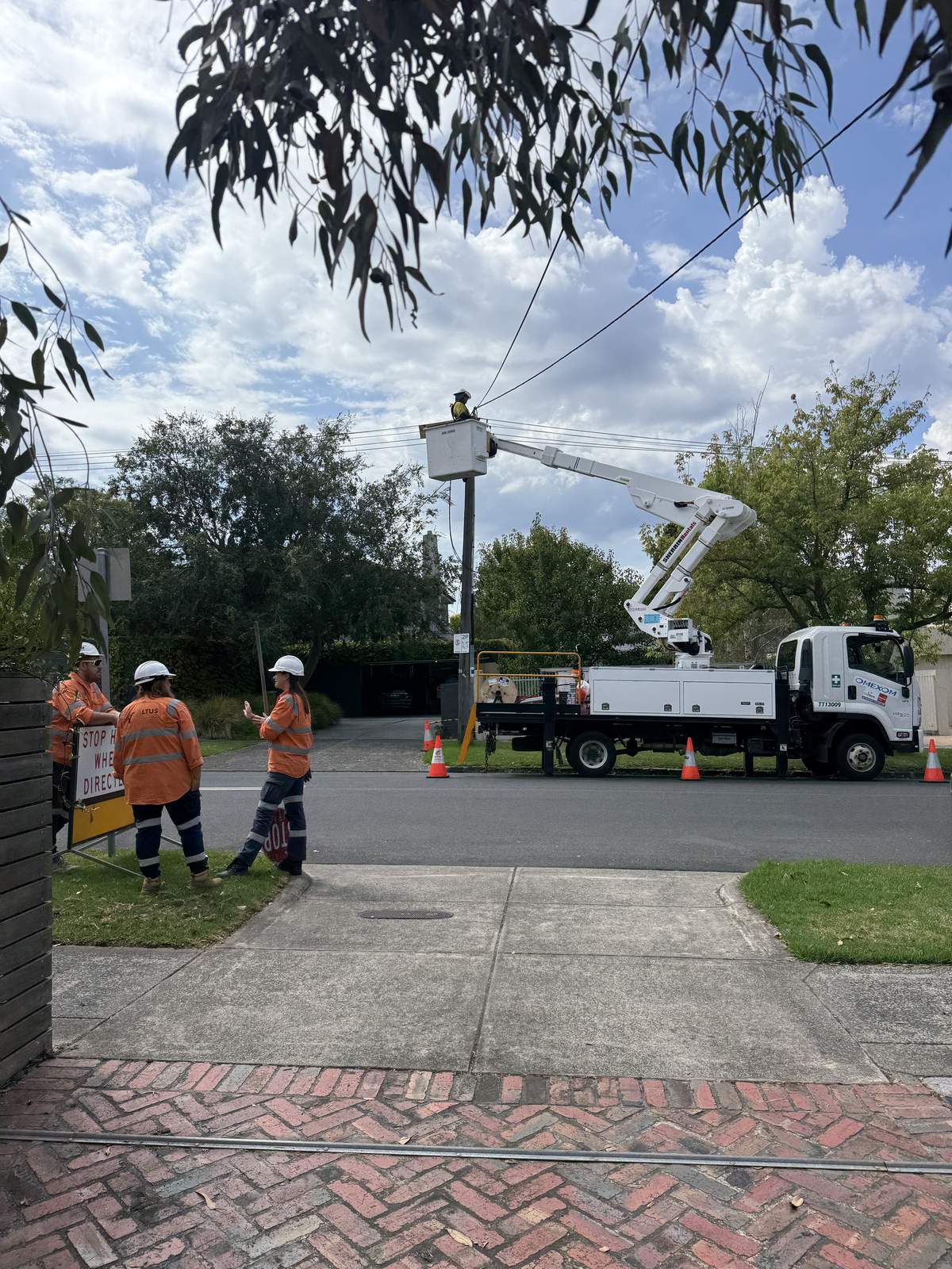 Cherry picker crew working on overhead power lines for electrical defect rectification