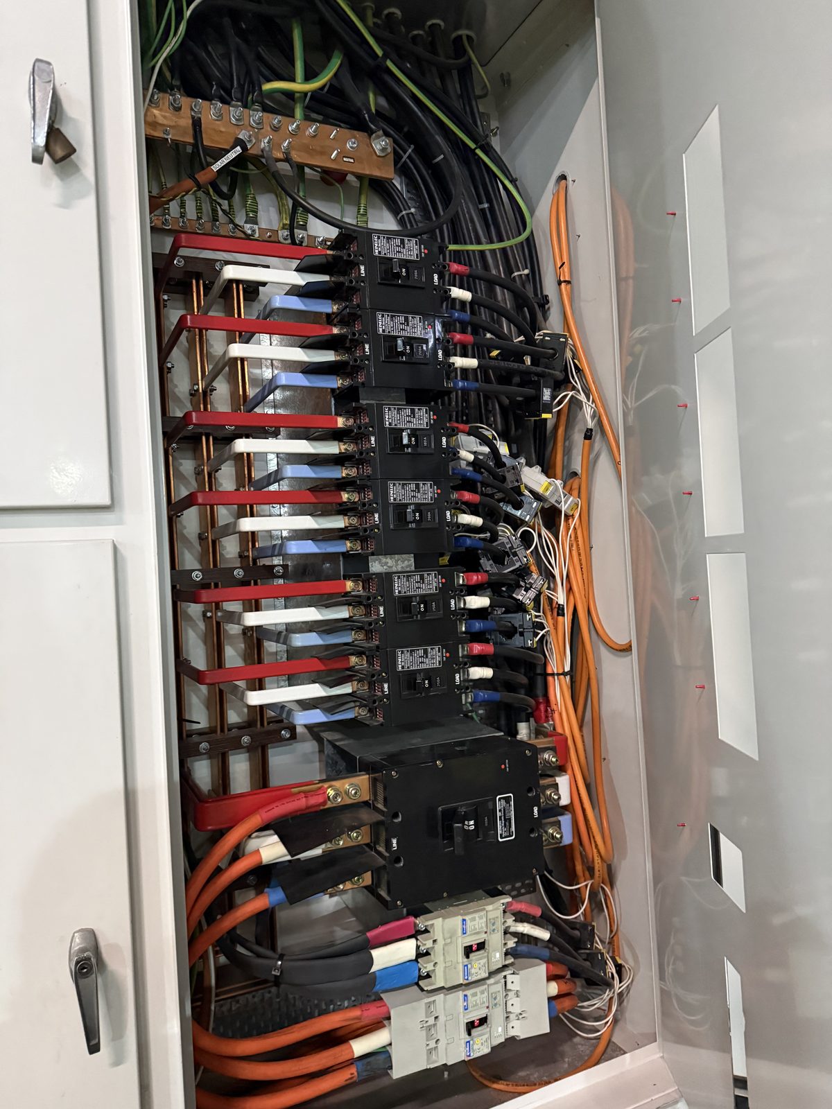 Commercial switchboard interior showing breakers busbars and cable terminations by Carlin Co Electrical